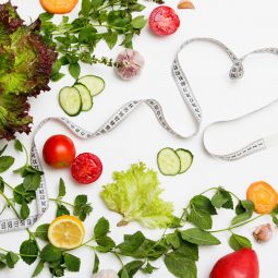 Zalety diety wegetariańskiej i wegańskiej jako koncepcja. Warzywa ułożone na stole razem z taśmą mierniczą w kształcie serca.