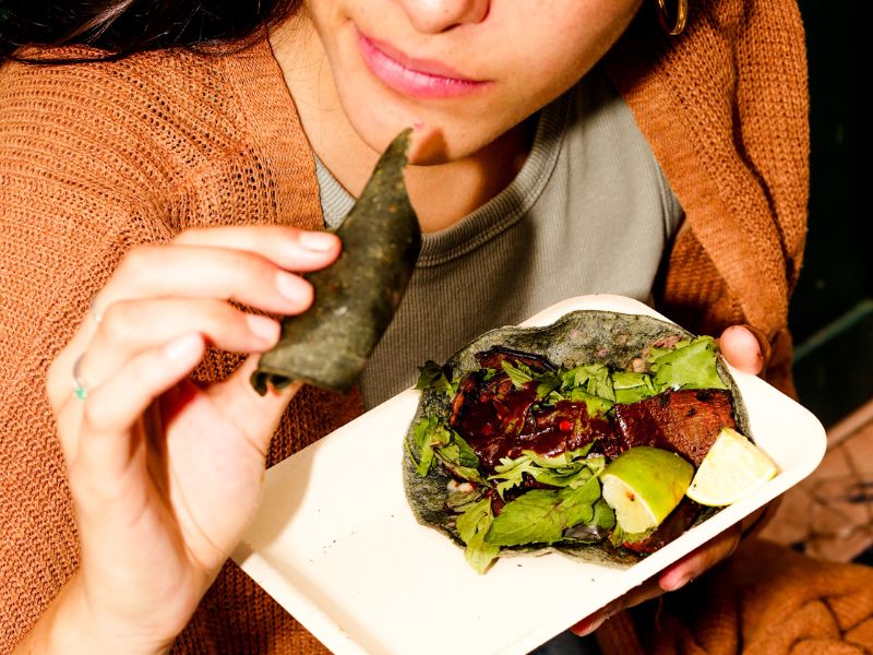 Jakie są wady wegetarianizmu? Na zdjęciu młoda wegetarianka spożywa posiłek.