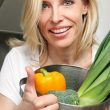 Czy wegetarianie żyją dłużej? Na zdjęciu kobieta wegetarianka gotuje.